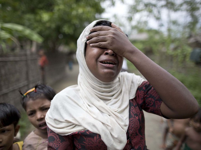 In this Oct. 13, 2015 photo, Salema Khatu reacts after seeing a photograph taken of her son, Habil, months before he died from complications related to tuberculosis in an area for Muslim refugees in north of Sittwe, western Rakhine state, Myanmar. Like other Rohingya Muslims living in Western Myanmar, the 10-year-old was unable to get proper medical treatment. As the predominantly Buddhist nation of 50 million started transitioning from dictatorship toward democracy in 2011, the rise in radical Buddhist nationalism has taking advantage of the newfound freedoms of expression to fan prejudices against the long-persecuted Rohingya Muslim minority. Hate-filled sermons have helped incite violence that began in 2012, leaving hundreds dead and sending a quarter-million others fleeing their homes. (AP Photo/Gemunu Amarasinghe)/XWS138/863246847448/OCT.13, 2015 PHOTO/1511030835
