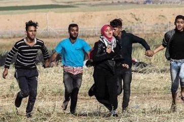 Des jeunes gazaouis protègent de leurs corps une jeune fille menacée par les tirs des tireurs israéliens