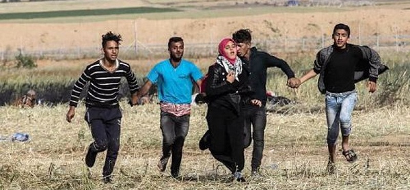 Des jeunes gazaouis protègent de leurs corps une jeune fille menacée par les tirs des tireurs israéliens