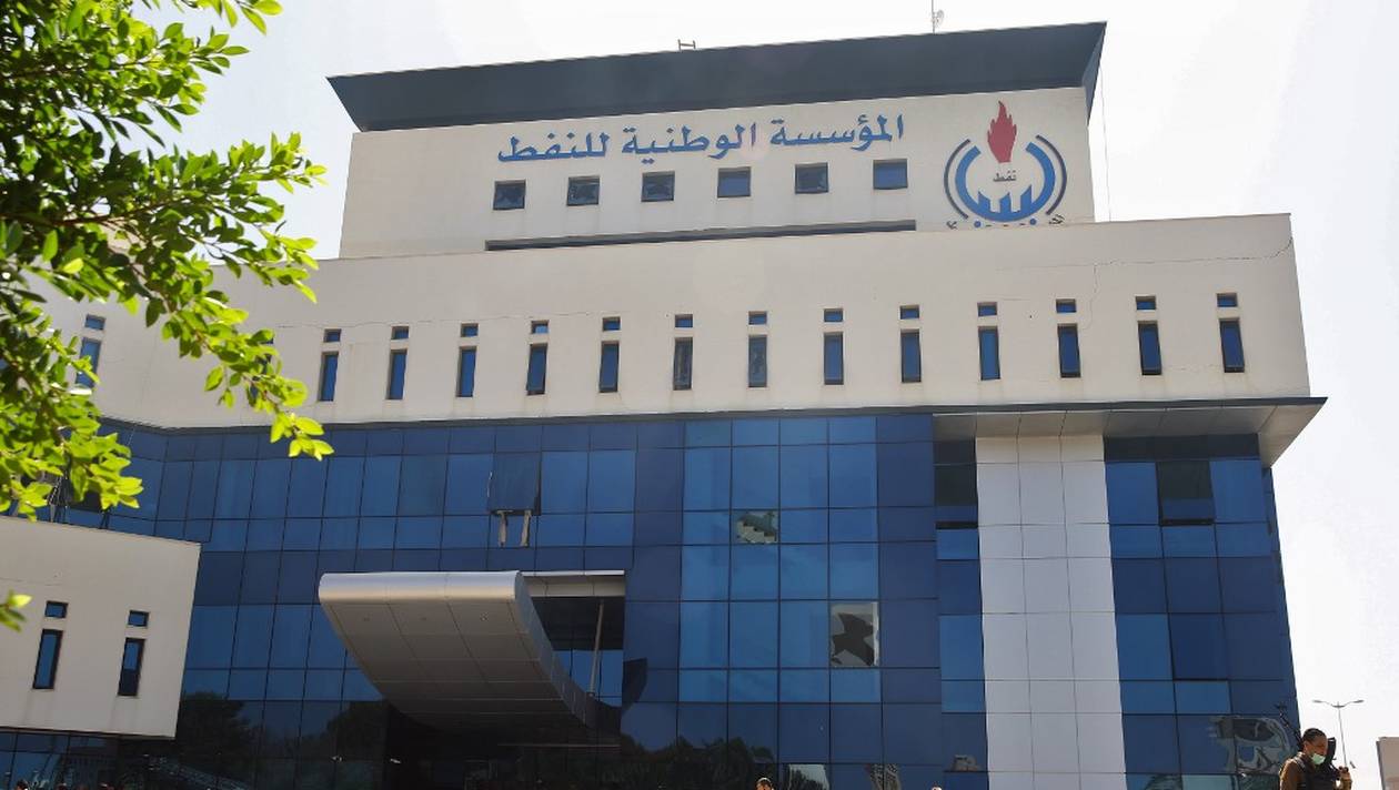 Onlookers gather in front of the headquarters of Libya's National Oil Company in the capital Tripoli on September 10, 2018. - Armed men stormed the building in Tripoli today where a blast and gunfire were heard, witnesses and a security source said. (Photo by Mahmud TURKIA / AFP)