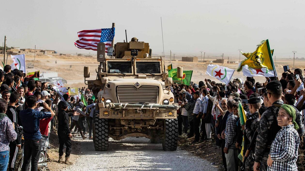 TOPSHOT - Syrian Kurds gather around a US armoured vehicle during a demonstration against Turkish threats next to a US-led international coalition base on the outskirts of Ras al-Ain town in Syria's Hasakeh province near the Turkish border on October 6, 2019.
Ankara had reiterated on October 5 an oft-repeated threat to launch an "air and ground" operation in Syria against a Kurdish militia it deems a terrorist group. / AFP / Delil SOULEIMAN