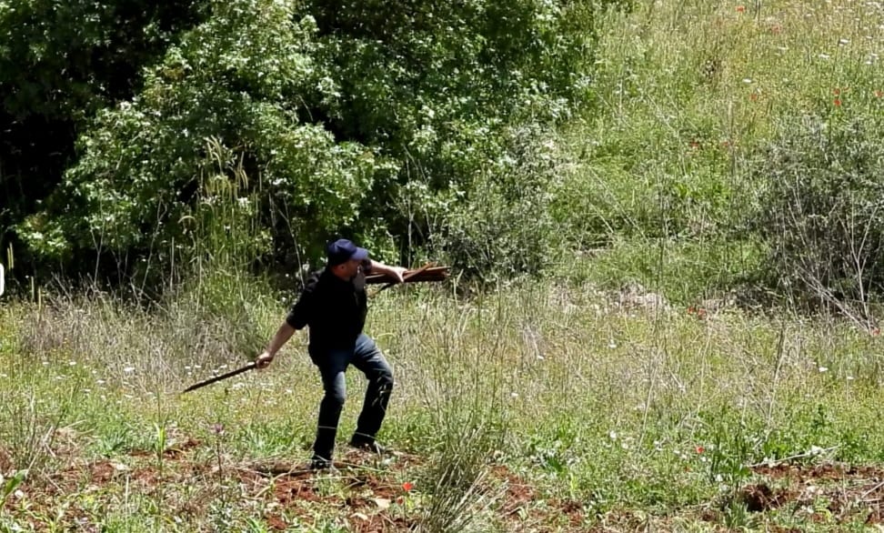 Un des habitants d'Aytaroun arrache un poteau israélien