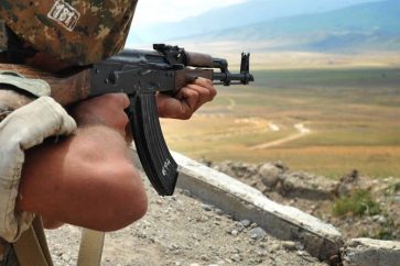 An Armenian soldier of the self-proclaimed republic of Nagorno-Karabagh aims his Kalashnikov assault rifle as he stands in a trench at the frontline on the border with Azerbaijan near the town of Martakert, on July 6, 2012. EU president Herman Van Rompuy urged last week enemies Armenia and Azerbaijan to end frontline clashes that have raised fears of renewed war over the disputed region of Nagorny Karabakh. Armenia-backed separatists seized Karabakh from Azerbaijan in a war in the 1990s that left some 30,000 dead, and no final peace deal has been signed since the 1994 ceasefire. Efthimiou  is on a visit to Armenia. AFP PHOTO /  KAREN MINASYAN
