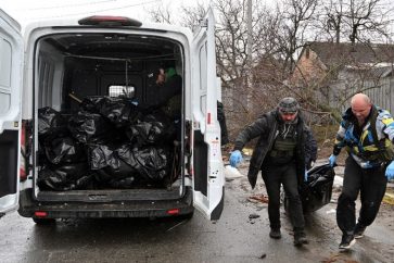 Des employés municipaux transportent des corps à Boutcha le 3 avril.