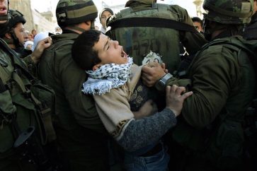 Un enfant palestinien détenu par des soldats israéliens lors d'une manifestation. ©AP