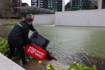 Des militants de Greenpeace ont transporté des contenants étiquetés "Stop Arming Israel/ Arrêtez d'Armer Israël" et versé un colorant rouge, biodégradable, dans un grand étang situé devant l'ambassade US à Londres.