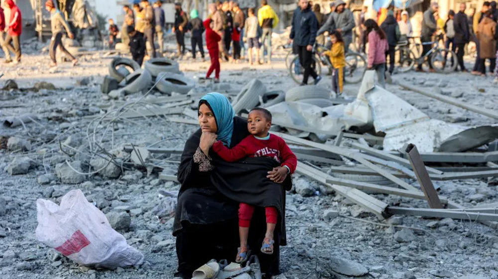 Une femme est assise avec un enfant sur le site d'un bombardement israélien sur un bloc résidentiel de la ville de Gaza le 14 janvier 2025. ©Getty Images