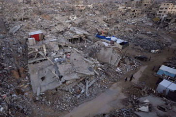 Des Palestiniens se tiennent près des décombres d'immeubles détruits, le 17 novembre 2025. ©Reuters